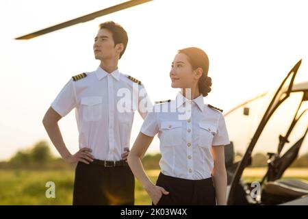 Chinesische Hubschrauberpiloten stehen neben dem Fahrzeug Stockfoto