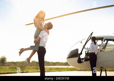 Junges chinesisches Paar, das mit dem Hubschrauber unterwegs ist Stockfoto
