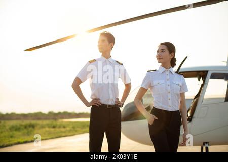 Chinesische Hubschrauberpiloten stehen neben dem Fahrzeug Stockfoto