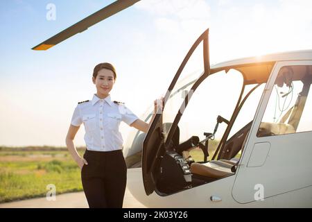 Chinesischer Hubschrauberpilot, der neben dem Fahrzeug steht Stockfoto