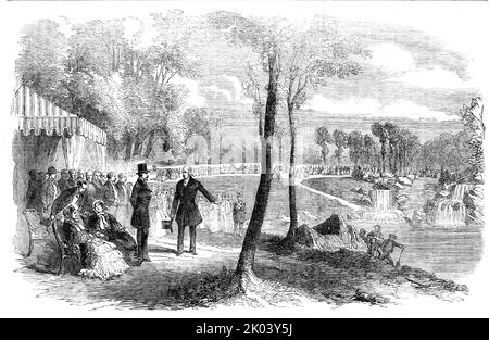 Einweihung der Kaskaden im Bois de Boulogne, Paris, durch den Kaiser und die Kaiserin der Franzosen, 1854. „Die Einweihung bestand in der Öffnung des Kanals durch den Kaiser [Napoleon III.] und der Lockerung des Wassers in den leeren See... als der See vollständig voll war, bot er ein wirklich schönes Bild, Die keine Anzeichen dafür trugen, dass sie mit künstlichen Mitteln hergestellt wurden...das verwendete Material bestand aus einer Lavaart...seine Majestät durchlief die Zeremonie der Lockerung des Wassers, das sofort in großem Volumen über die Felsen fiel und eine sehr große Größe bildete Stockfoto