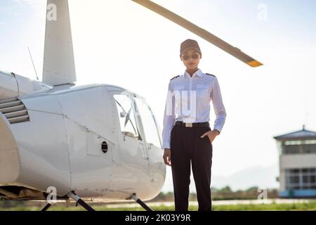 Chinesischer Hubschrauberpilot, der neben dem Fahrzeug steht Stockfoto