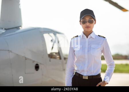 Chinesischer Hubschrauberpilot, der neben dem Fahrzeug steht Stockfoto