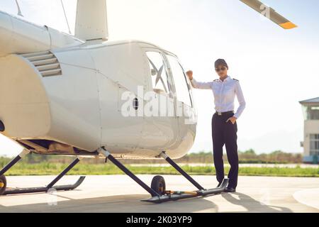 Chinesischer Hubschrauberpilot, der neben dem Fahrzeug steht Stockfoto