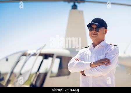 Chinesischer Hubschrauberpilot, der neben dem Fahrzeug steht Stockfoto