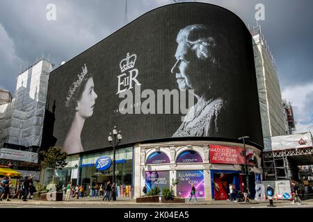 London, Großbritannien. 9.. September 2022. Bilder von Königin Elizabeth II., die nach ihrem Tod am 8.. September 2022 auf Bildschirmen im Piccadilly Circus zu Ehren ihrer Majestät gezeigt wurden. Stockfoto