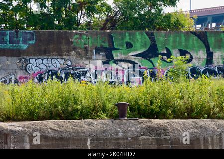 Graffiti an der Wand neben dem Cuyahoga River Damm in Cleveland Ohio Stockfoto