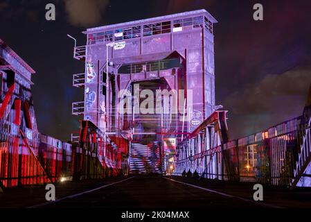 Magdeburg, Deutschland. 09. September 2022. Die Magdeburger Liftbrücke wird von bunten Scheinwerfern beleuchtet. Neben der Brücke, einem Wahrzeichen der Stadt, startete am Abend das dreitägige Festival Kulturbrücke. Das Programm umfasst Konzerte, Theateraufführungen, Lesungen und Tanzworkshops. Quelle: Stephan Schulz/dpa/Alamy Live News Stockfoto