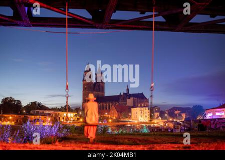 Magdeburg, Deutschland. 09. September 2022. Eine Frau schwingt auf der Elbe mit Blick auf den Magdeburger Dom. Das dreitägige Festival der Kulturbrücke begann heute Abend in der Landeshauptstadt. Das Programm umfasst Konzerte, Theateraufführungen, Lesungen und Tanzworkshops. Quelle: Stephan Schulz/dpa/Alamy Live News Stockfoto