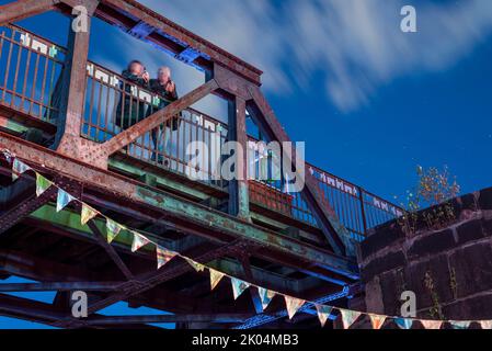 Magdeburg, Deutschland. 09. September 2022. Zwei Festivalbesucher stehen auf der historischen Liftbrücke, einem Wahrzeichen der Stadt Magdeburg. Das dreitägige Festival der Kulturbrücke begann am Abend in der Landeshauptstadt. Das Programm umfasst Konzerte, Theateraufführungen, Lesungen und Tanzworkshops. Quelle: Stephan Schulz/dpa/Alamy Live News Stockfoto