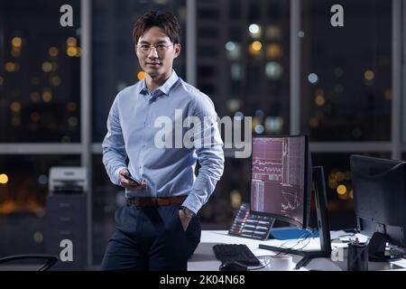 Chinesischer Geschäftsmann, der nachts im Büro arbeitet Stockfoto