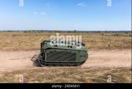 Evakuierungsroboter Them wird während der Feldtests auf einer staubigen Straße gesehen. Feldtests der Multizweck-Crawler-Drohne Themis der estnischen Firma Milrem Robotics, die vom medizinischen Bataillon „Hospitalers“ für Evakuierungszwecke an der Front verwundete Soldaten eingesetzt werden soll. Der Evakuierungsroboter „Zhuravel“ bestand den ersten Test. Der Roboter wird an vorderster Front eingesetzt, an Orten, an denen es für Mediziner schwierig ist, mit dem Fahrzeug oder zu Fuß zu erreichen. Stockfoto