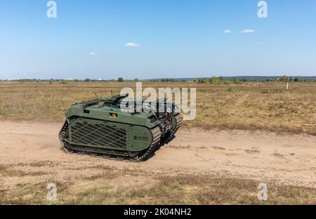 Evakuierungsroboter Them wird während der Feldtests auf einer staubigen Straße gesehen. Feldtests der Multizweck-Crawler-Drohne Themis der estnischen Firma Milrem Robotics, die vom medizinischen Bataillon „Hospitalers“ für Evakuierungszwecke an der Front verwundete Soldaten eingesetzt werden soll. Der Evakuierungsroboter „Zhuravel“ bestand den ersten Test. Der Roboter wird an vorderster Front eingesetzt, an Orten, an denen es für Mediziner schwierig ist, mit dem Fahrzeug oder zu Fuß zu erreichen. Stockfoto