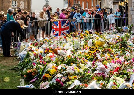 Windsor, Großbritannien. 9.. September 2022. Einen Tag nach dem Tod von Königin Elizabeth II. Am 9.. September 2022 in Windsor, Großbritannien, hinterlässt eine Frau einen Blumenschmuck vor dem Cambridge Gate im Schloss Windsor. Königin Elizabeth II., die dienstälteste Monarchin Großbritanniens, starb in Balmoral im Alter von 96 Jahren nach einer Regierungszeit von 70 Jahren. (Foto von Mark Kerrison/in Pictures via Getty Images) Quelle: Mark Kerrison/Alamy Live News Stockfoto