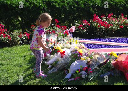 Washington DC, USA. 09. September 2022. Ein Mädchen legt Blumen an ein provisorisches Denkmal für Königin Elizabeth II. Vor der britischen Botschaft. Quelle: Philip Yabut/Alamy Live News Stockfoto