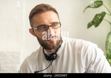 Kopf geschossen Porträt lächelnd kaukasischen Mann sitzt drinnen mit angenehmen Web-Cam Videokonferenz Online-Chat von der Arbeit oder informellen sprechen PC. Job Stockfoto