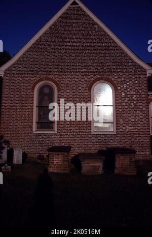 Petersburg, VA. USA. 9/1993. Blandford Church oder St. Paul’s Church oder The Brick Church. Erbaut um 1736 auf Wells Hill. Zwischen 1904 und 1912 wurden 15 Fenster installiert. Die meisten zeigen ein Staatssiegel, die Figur eines heiligen und eine Inschrift. Elf wurden von jedem der ehemaligen Bundesstaaten gestiftet. Ein Buntglasfenster eines christlichen Juwelenkreuzes, das von Louis Comfort Tiffany gestiftet wurde. Das Kirchengebäude wurde 1806 aufgegeben. Während des Bürgerkrieges diente die Kirche als große Telegrafenstation. Es wurde als Feldlazarett verwendet, vor allem nach der Schlacht am Krater. Stockfoto