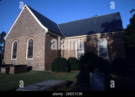 Petersburg, VA. USA. 9/1993. Blandford Church oder St. Paul’s Church oder The Brick Church. Erbaut um 1736 auf Wells Hill. Zwischen 1904 und 1912 wurden 15 Fenster installiert. Die meisten zeigen ein Staatssiegel, die Figur eines heiligen und eine Inschrift. Elf wurden von jedem der ehemaligen Bundesstaaten gestiftet. Ein Buntglasfenster eines christlichen Juwelenkreuzes, das von Louis Comfort Tiffany gestiftet wurde. Das Kirchengebäude wurde 1806 aufgegeben. Während des Bürgerkrieges diente die Kirche als große Telegrafenstation. Es wurde als Feldlazarett verwendet, vor allem nach der Schlacht am Krater. Stockfoto