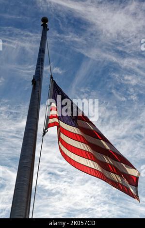Owensboro, KY, USA. 09. September 2022. Eine amerikanische Flagge vor einer Bank fliegt am Tag nach ihrem Tod auf einen halben Stab zu Ehren von Königin Elizabeth II., Monarchin des Vereinigten Königreichs und des Commonwealth Realms. Der Gouverneur von Kentucky hat angeordnet, dass die Flaggen an allen staatlichen Gebäuden bis zum Sonnenuntergang am Tag der Interrementszeit auf die Hälfte des Personals gesenkt werden und ermutigt private Unternehmen und Einzelpersonen, sich an der Tribute zu beteiligen. Die 13 Streifen auf der Flagge stellen die ursprünglichen 13 britischen Kolonien dar, die schließlich die Vereinigten Staaten von Amerika wurden. (Kredit: Billy Suratt/Apex MediaWire über Alamy Live News) Stockfoto