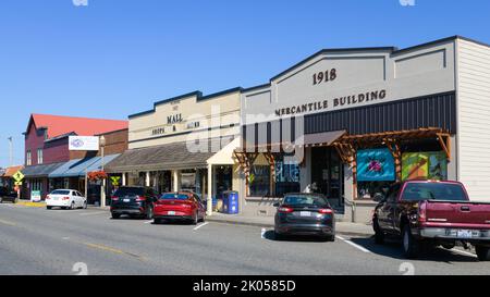 Stanwood, WA, USA - 11. August 2022; Alte Gebäude in der Innenstadt von Stanwood Washington mit Autos schräg vor den Geschäften geparkt Stockfoto