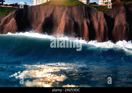Klippe mit Gebäuden Malecon de Miraflores vom Meer aus gesehen mit Wellen an einem sonnigen Tag Stockfoto