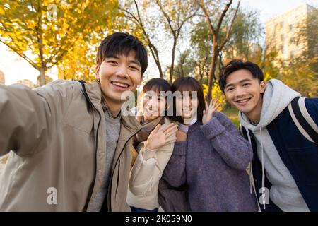 Glückliche chinesische Studenten, die Selfie auf dem Campus machen Stockfoto