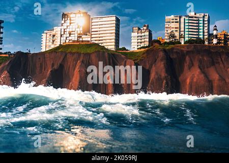 Klippe mit Gebäuden Malecon de Miraflores vom Meer aus gesehen mit Wellen an einem sonnigen Tag Stockfoto