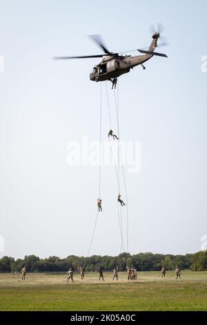 US-Soldaten und Luftwaffe führen am 8. September 2022 Abseilen von einem UH-60 Black Hawk im Rahmen des Air Assault Course in Camp Dodge in Johnston, Iowa, durch. Mehr als 200 Soldaten und Luftwaffe nahmen an einem 12-tägigen Luftangriff der US-Armee in Camp Dodge Teil, der Dienstmitglieder bei Schleuderbelastungen und Absellängen ausbildet und gleichzeitig ein Test der Körnung ist. (USA Foto der Armee-Nationalgarde von Staff Sgt. Samantha Hircock) Stockfoto