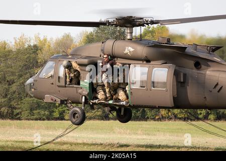 Die US Army Air Assault Kader beaufsichtigt Abseilen von einem UH-60 Black Hawk als Teil des Air Assault Course am 8. September 2022 in Camp Dodge in Johnston, Iowa. Mehr als 200 Soldaten und Luftwaffe nahmen an einem 12-tägigen Luftangriff der US-Armee in Camp Dodge Teil, der Dienstmitglieder bei Schleuderbelastungen und Absellängen ausbildet und gleichzeitig ein Test der Körnung ist. (USA Foto der Armee-Nationalgarde von Staff Sgt. Samantha Hircock) Stockfoto