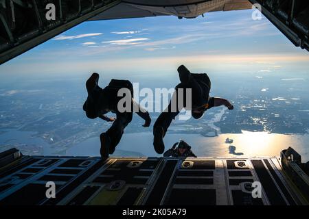 Mitglieder, die gemeinsamen Spezialeinsatzkräften auf der MacDill Air Force Base, Florida, zugewiesen wurden, springen aus einem C-130 Hercules-Flugzeug, das dem Rettungsflügel 920., der Patrick Space Force Base, Florida, über Tampa, Florida, zugewiesen wurde, 31. August, 2022. Mitglieder der gemeinsamen Spezialeinsatzkräfte, die dem U.S. Special Operations Command, Special Operations Command Central und dem Joint Communications Support Element zugewiesen sind, führten im Rahmen einer monatlichen Trainingsanforderung eine administrative, nicht taktische Freifalloperation über MacDill durch. (USA Luftwaffe Foto von Airman 1. Klasse Joshua Hastings) Stockfoto