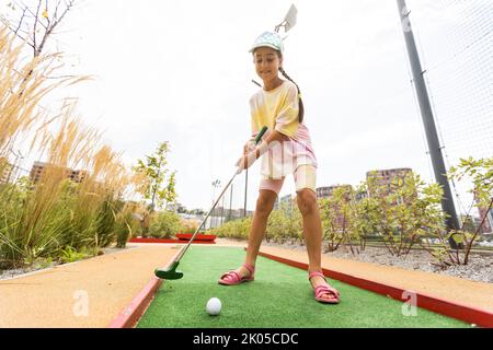 Schöne kleine Mädchen spielen Mini Golf Stockfoto