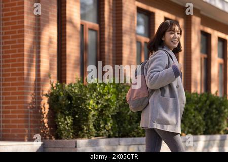 Glücklicher chinesischer College-Student auf dem Campus Stockfoto