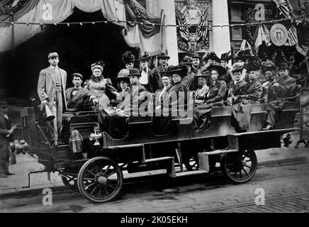 Ein früher Bus transportiert eine Gruppe gut gekleideter Erwachsener -- möglicherweise in einer patriotischen Parade, ca. 1895. Stockfoto