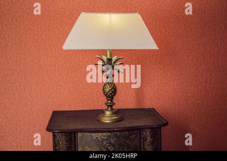 Helles Eco-Licht in der Ecke eines modernen Schlafzimmers. Neue LED-Technologie trifft auf traditionelles Innendesign. Lampe schafft gemütliche Atmosphäre im Zimmer Stockfoto