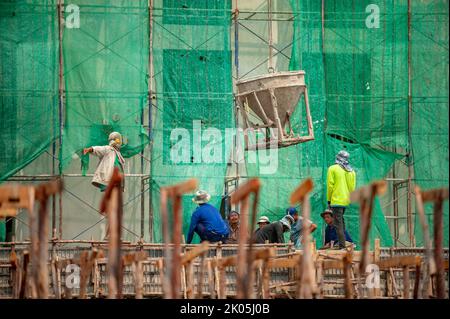 Bangkok, Thailand 5. September 2015: Betoneimer mit Kran heruntergehoben, der ein Team von Bauarbeitern darunter ablieferte. Stockfoto