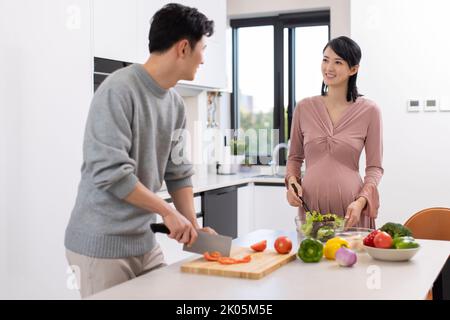 Happy Chinese schwanger Frau und Mann Kochen in der Küche Stockfoto