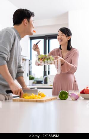 Happy Chinese schwanger Frau und Mann Kochen in der Küche Stockfoto