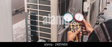 Der Techniker überprüft die Funktion der Klimaanlage. Stockfoto