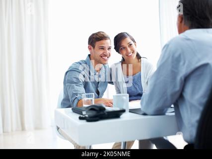 Paar hören dem Finanzberater zu. Porträt eines jungen Paares, das im Büro dem Finanzberater zuhört. Stockfoto