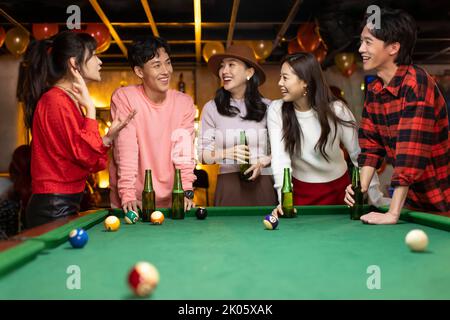 Glückliche junge chinesische Freunde trinken Bier Stockfoto