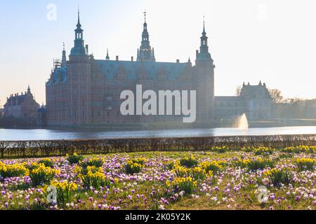 Ansicht des Schlosses Frederiksborg in Hillerod, Dänemark. Schöner See und Garten mit Krokussen und Narzissen im Vordergrund Stockfoto