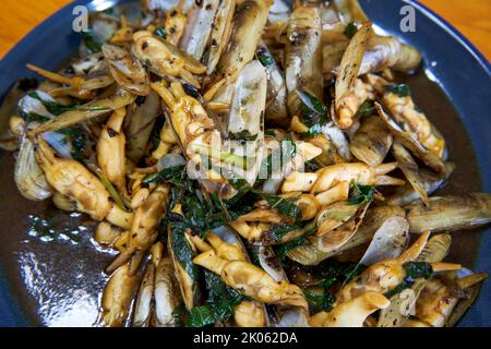 Ein köstliches und süßes chinesisches Gericht, gebratene Venusmuscheln mit Basilikum und Tempeh Stockfoto