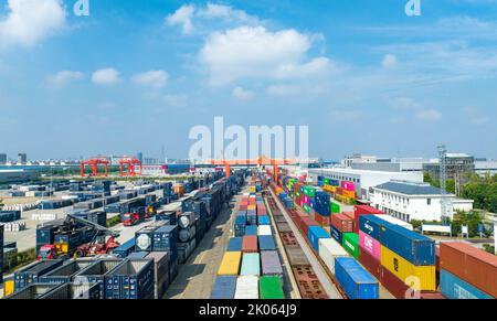 NANTONG, CHINA - 10. SEPTEMBER 2022 - am Haian Railway Logistics-Stützpunkt in Nantong, Jiang, betreiben Arbeiter schwere Hebezeuge zum Anheben von Containern Stockfoto