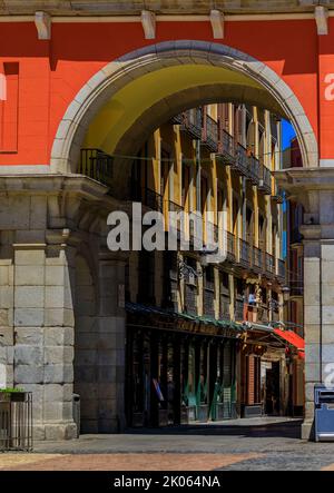 Tor zur Plaza Mayor, umgeben von Cafés und Restaurants entlang der Bögen mit Blick auf die Calle de la Sal in Madrid, Spanien Stockfoto