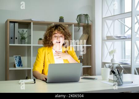 Der Geschäftserfolg überraschte die Arbeitnehmerin, den Laptop Stockfoto