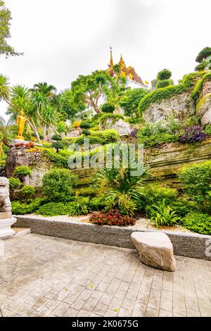 Kleiner Garten mit Wasserteich, Buddha-Statue und Blumen in der Nähe des Wat Saket-Tempels (Goldener Berg) in Bangkok, Thailand. Auf der Oberseite befindet sich ein berühmtes Religionsgebäude Stockfoto