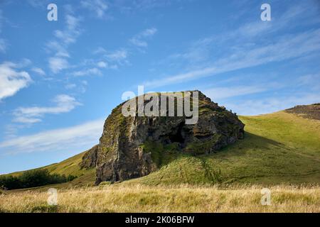 Felsen in grüner Landschaft und blauem Himmel in der Nähe des Vulkans Eyjafjallajökull, Südisland. Stockfoto