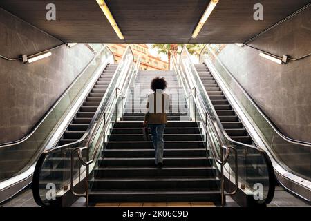 Rückansicht einer Geschäftsfrau, die die Treppe hinauf ging Stockfoto