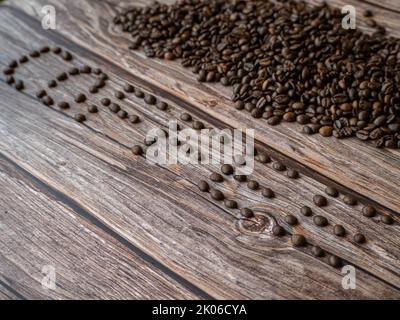 Das Wort Kaffee aus Kaffeebohnen auf Holzhintergrund Stockfoto