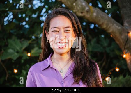 Glücklich asiatische Mädchen beim Blick auf Kamera. Nahaufnahme Porträt einer chinesin, die bei Sonnenaufgang im Freien lacht und lächelt. Stockfoto